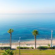 A woman sits alone on the sandy beach at the resort town of Palaio Faliro, Greece.